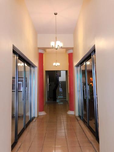 a hallway with glass doors and a man standing in the distance at Santa Fe Hotel Boutique in Tapachula