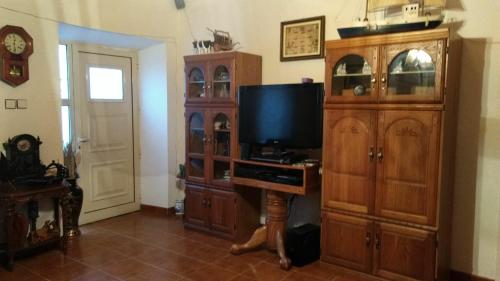 a living room with a tv and a wooden entertainment center at Pandora in Faja Grande