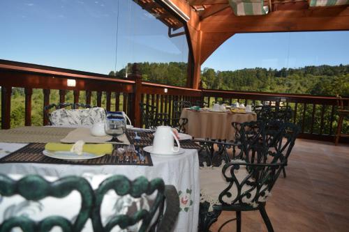 a patio with tables and chairs on a deck at Finca Paraiso Mountain Retreat near San Jose Airport in Birrí