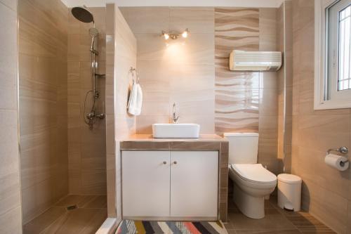 a bathroom with a white sink and a toilet at Casa Jokaste in Karpathos