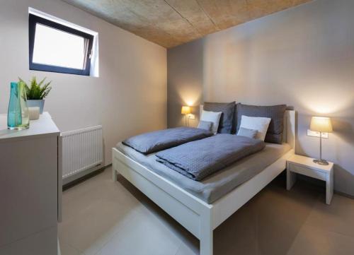 ein Schlafzimmer mit einem Bett mit zwei Lampen in der Unterkunft Nerudovka apartment in Karlsbad