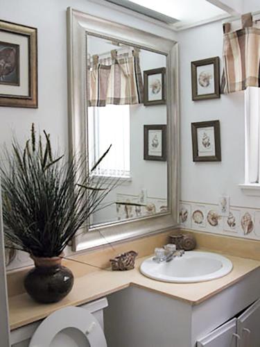 a bathroom with a sink and a mirror and a toilet at 25 Steps to the Beach in Newport Beach