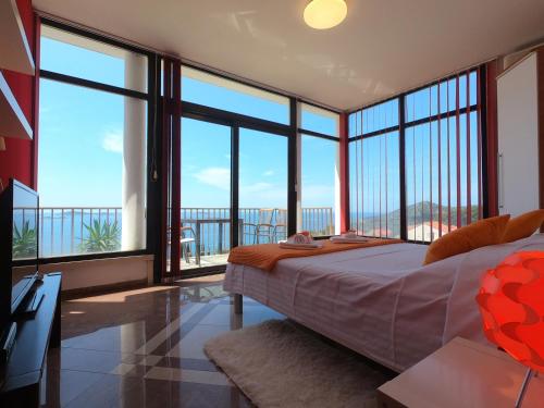 a bedroom with a bed and large glass windows at Apartments La Perla in Mlini