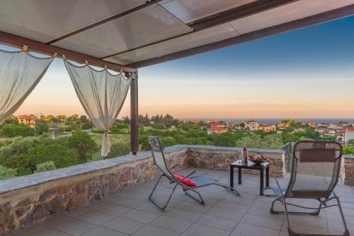 a balcony with two chairs and a table with a view at Eco Villa in Mákri