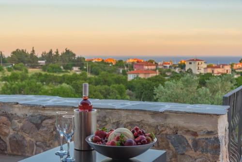 a bowl of fruit on a table with a wine glass at Eco Villa in Mákri