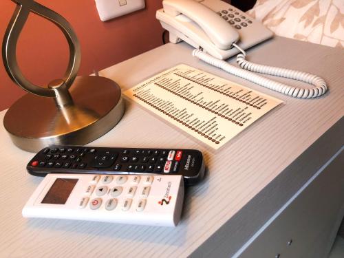 a desk with a phone and a calculator and a remote control at Santa Fe Hotel Boutique in Tapachula
