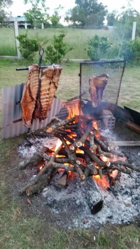 een grill met een hoop vlees en vlammen bij Los manzanos . in Colón