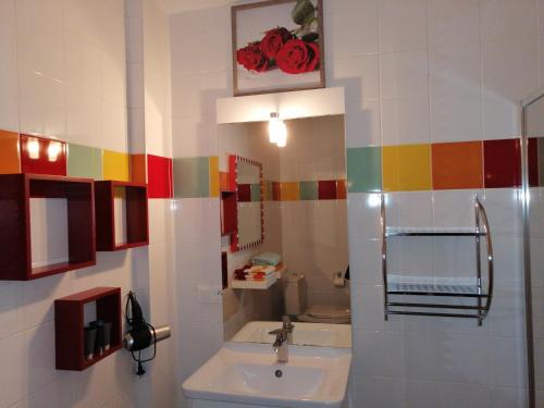 a bathroom with a sink and a colorful tile wall at Coeur d'Elsass "RAPP"appartement avec parking in Colmar