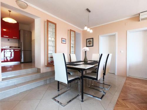 a dining room with a black table and white chairs at Apartments La Perla in Mlini