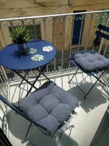 a blue table and two chairs on a balcony at Little Blue House in Marsalforn