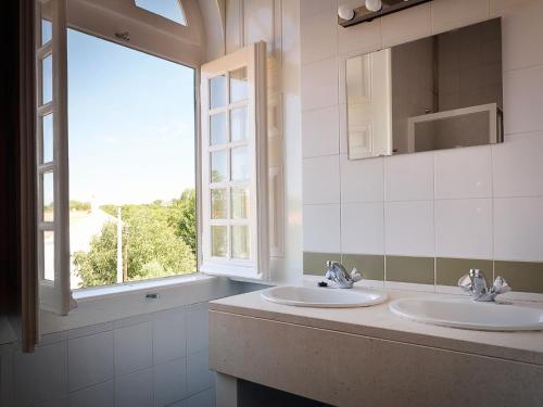 a bathroom with two sinks and a window at Train Spot Guesthouse in Marvão