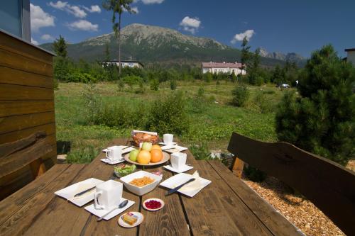 una mesa de madera con un bol de fruta. en Mountain Villas Polana, en Nový Smokovec