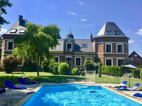 une grande maison avec une piscine devant dans l'établissement Chateau de la Vallee, Normandy, à Grandcourt