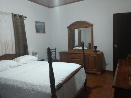 a bedroom with a bed and a dresser and a mirror at Pandora in Faja Grande