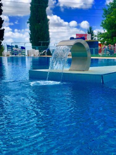 a fountain in the middle of a swimming pool at pisgat shoresh in Shoresh