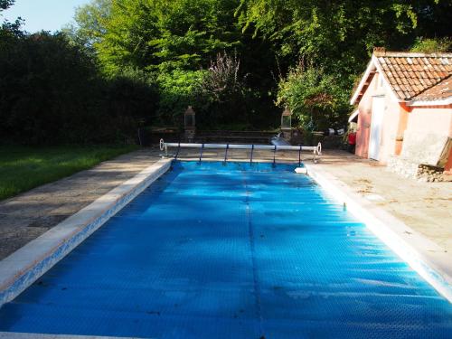a pool of blue water with a bench in it at West Cottage, Cerne Abbas Lane in Dorchester