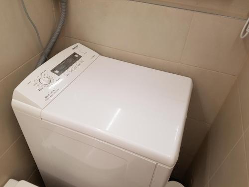 a white toilet with a remote control on top of it at Souterrain Solln 20min Oktoberfest/Zentrum in Munich