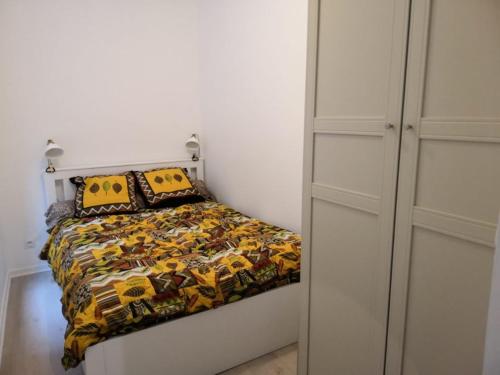 - une chambre avec un lit doté d'une couette jaune et noire dans l'établissement Appartement Rouen Cathédrale avec terrasse, à Rouen