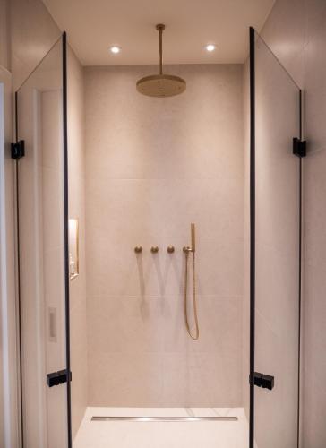 a shower with a glass door in a bathroom at Alpenloge Design Hotel in Scheidegg