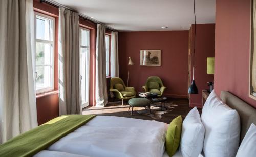 a hotel room with a bed and windows at Alpenloge Design Hotel in Scheidegg