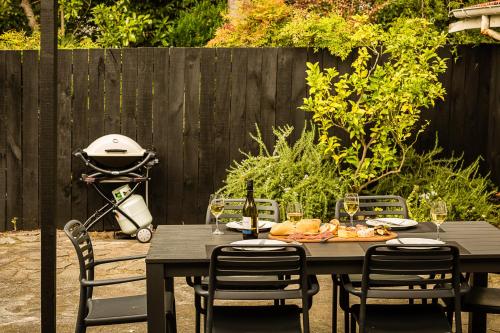 a black table with chairs and wine glasses at Deco Villa in Havelock North