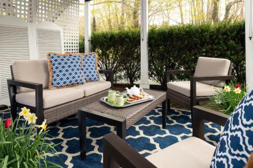 a patio with two chairs and a table with a tray of food at Candleberry Inn on Cape Cod in Brewster