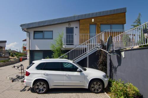 a white car parked in front of a house at Mountain Villas Polana in Smokovce