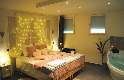 - une chambre avec un lit éclairé et une baignoire dans l'établissement Suite & SPA, à Avignon