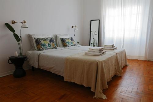 een slaapkamer met een bed en een tafel met handdoeken bij AL CASA GRANDE in Olhão