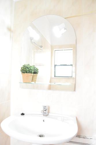 Un baño blanco con lavabo y espejo. en MemSoares Country House, en Castelo de Vide