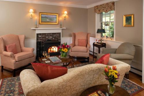 a living room with a couch and chairs and a fireplace at Candleberry Inn on Cape Cod in Brewster