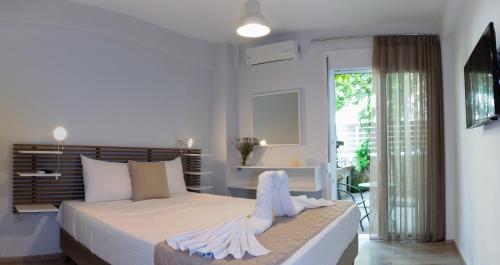 een witte slaapkamer met een bed en een balkon bij Urban 35 in Chania