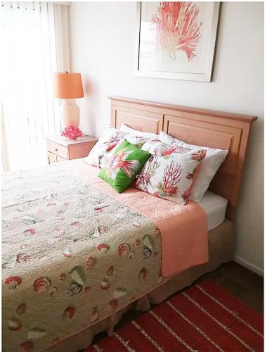 a bedroom with a bed with pillows and a lamp at 25 Steps to the Beach in Newport Beach