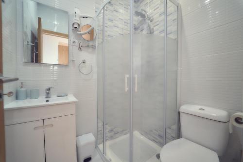 a bathroom with a shower with a toilet and a sink at Hostel Matosinhos Suites in Matosinhos