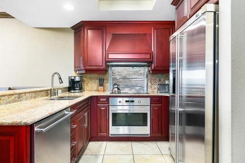 a kitchen with red cabinets and stainless steel appliances at Condos at Canyons Resort by White Pines in Park City