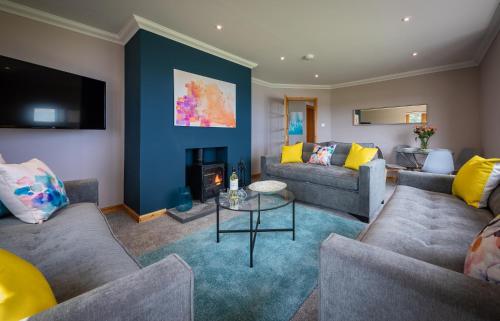 a living room with two couches and a fireplace at Taste of the Sea in Staffin