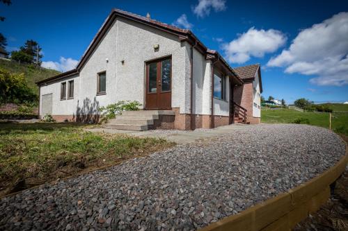 a house with a gravel driveway at Taste of the Sea in Staffin