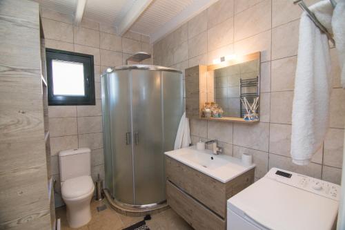 a bathroom with a shower and a toilet and a sink at Villa Venetia Corfu in Agnítsini