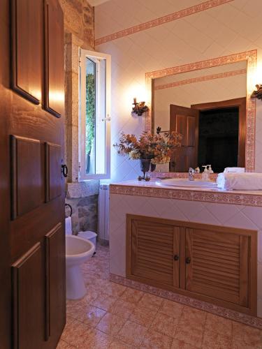 a bathroom with a sink and a toilet and a mirror at Quinta da Casa Alta in Valença