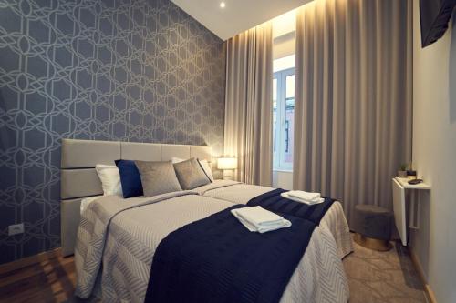 a bedroom with a bed with two towels on it at Hostel Matosinhos Suites in Matosinhos