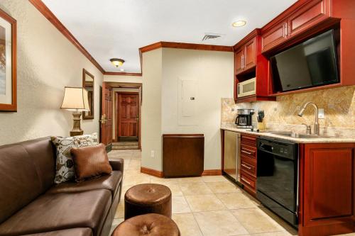 a living room with a couch and a kitchen at Condos at Canyons Resort by White Pines in Park City