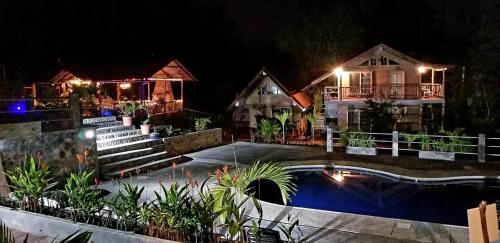 a house with a swimming pool at night at La Casa del Rio B&B in Puyo