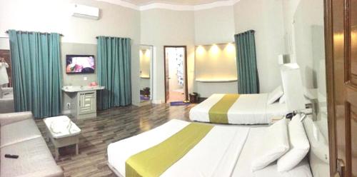 Habitación de hotel con 2 camas y TV en Star Guest House en Karachi