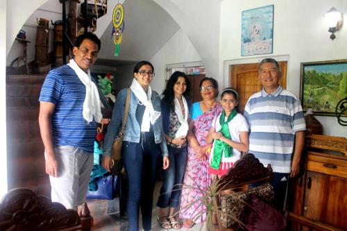 a family posing for a picture in a room at Mansarover Home Stay in Kalimpong