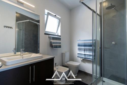 a bathroom with a sink and a toilet and a shower at White House I in Praia da Vitória