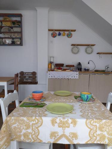 a kitchen with a table with plates on it at Casas do Ardila in Santo Amador