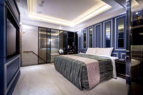 a bedroom with a large bed and a television at OUGE Motel - Fengshan in Kaohsiung