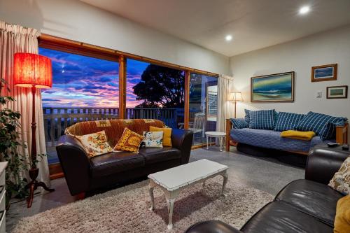 a living room with a couch and a table at A Room With a View in Kaikoura