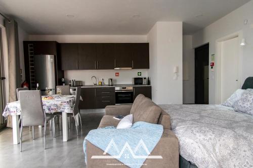 a living room and kitchen with a couch and a table at White House II in Praia da Vitória