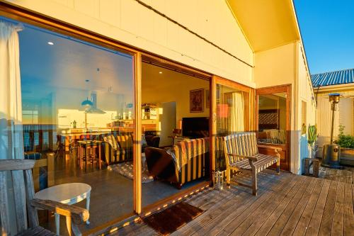 a porch with glass doors and furniture on a deck at A Room With a View in Kaikoura